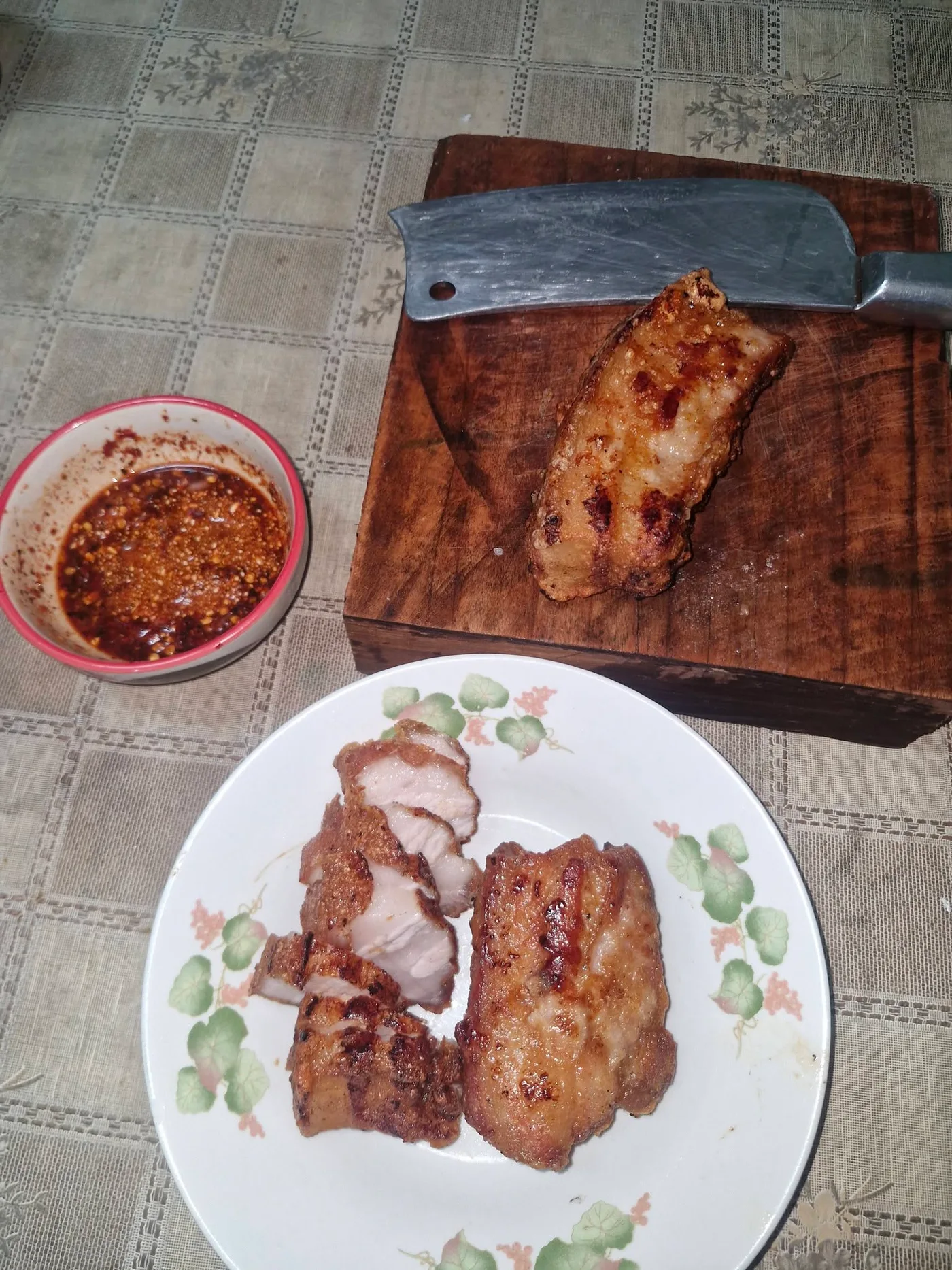 หมูสามชั้นทอดบนเขียงและจาน พร้อมถ้วยน้ำจิ้มแจ่ว